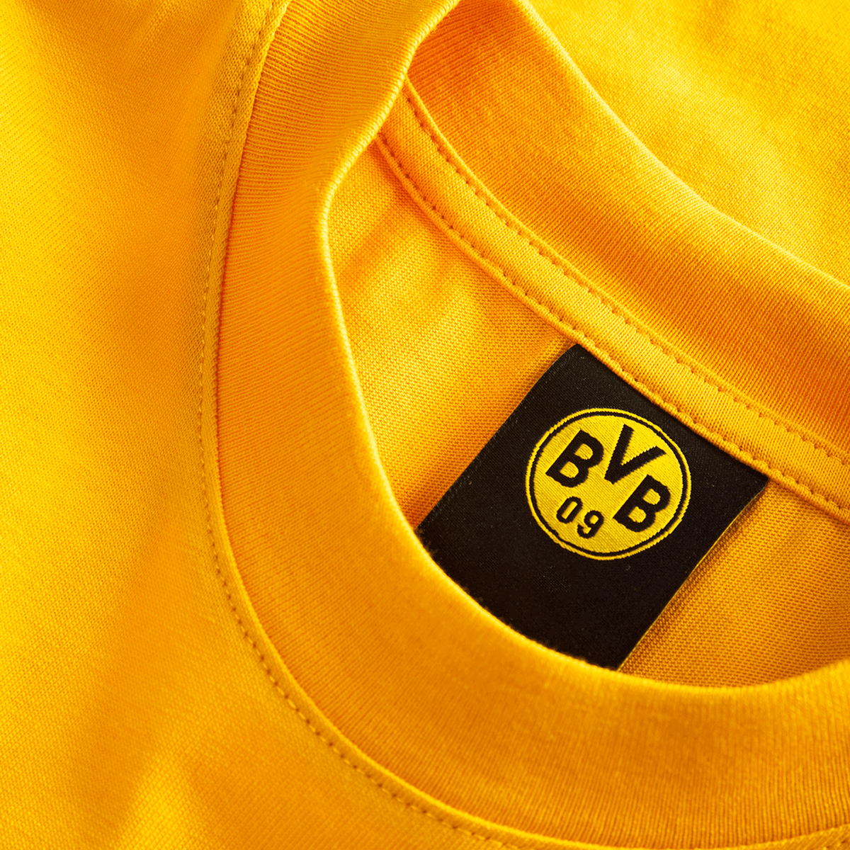 Maglietta gialla del BVB Essentials II per bambini, in cotone, con il logo BVB 09 sull'etichetta interna. Perfetta per i tifosi del Borussia Dortmund.