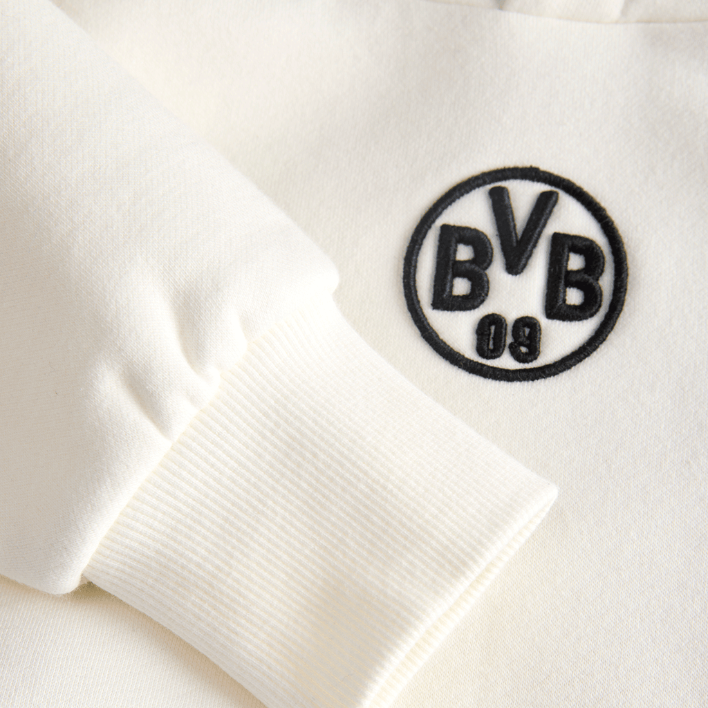 BVBの刺繍ロゴとリブ編みの袖口が特徴の、キッズ用ベージュのBVBフーディー「Essentials II」のディテール写真。
