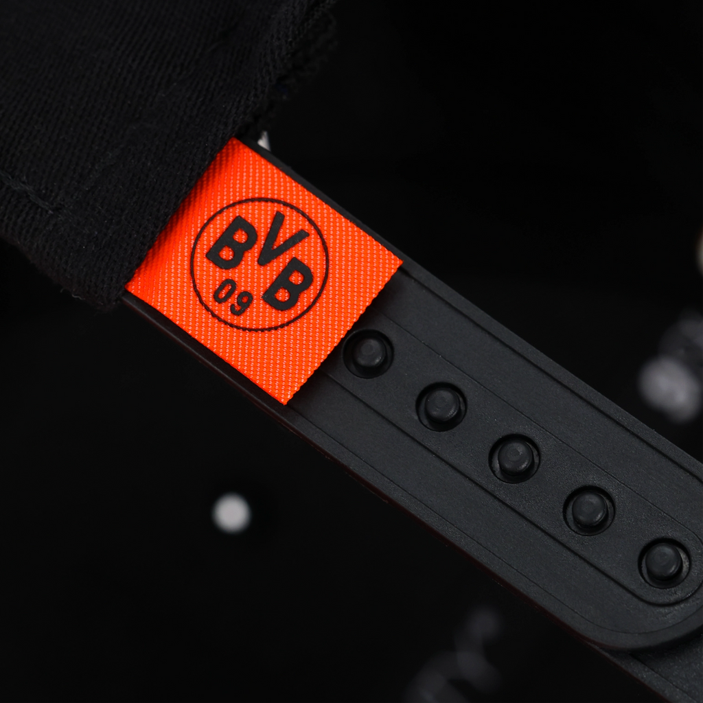 Immagine ravvicinata di un cappellino BVB New Era 9SEVENTY nero con etichetta rossa e logo BVB 09 stampato.