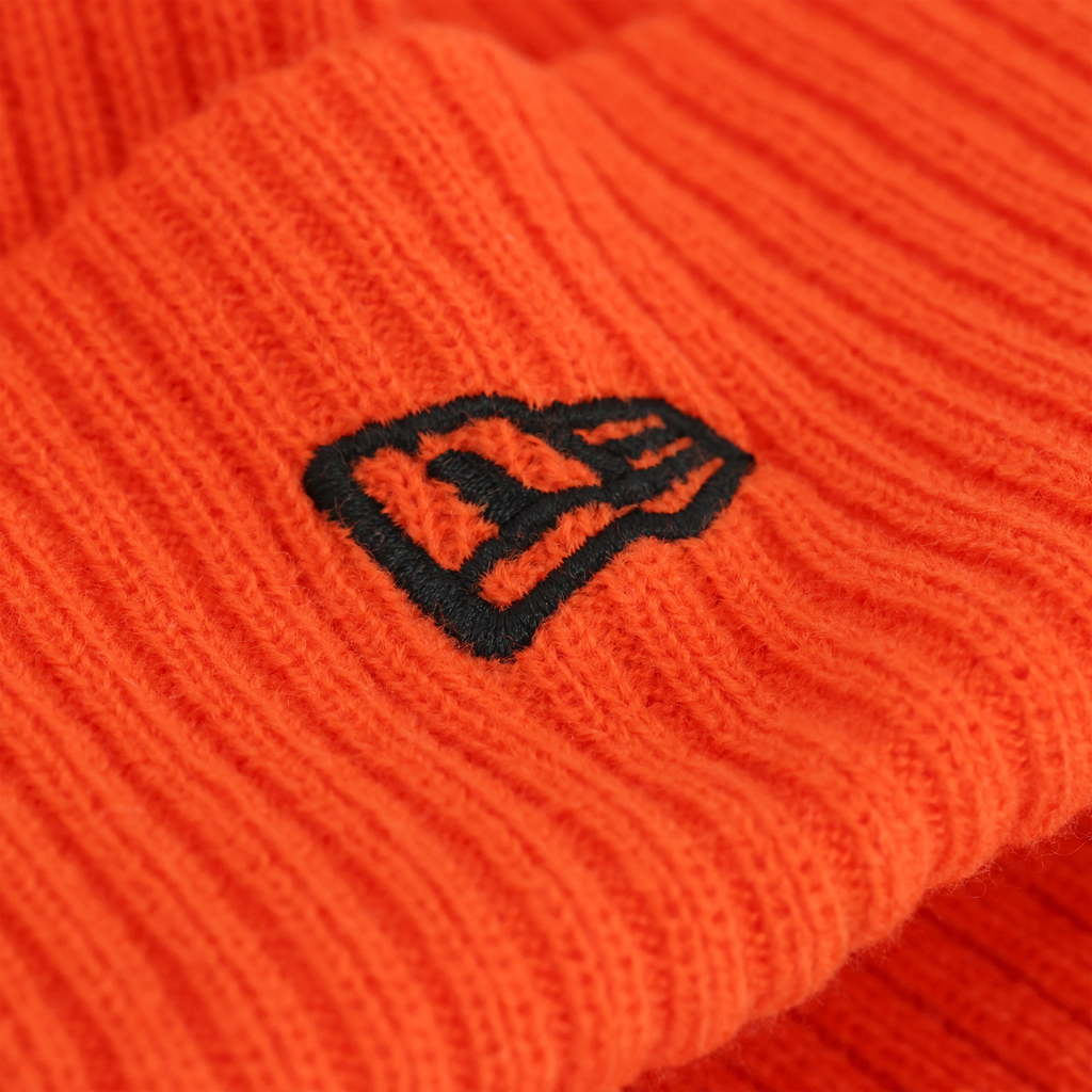 Vue détaillée du bonnet en tricot orange HEAT II du BVB de la marque New Era, orné d'un logo noir : un accessoire élégant pour les supporters.