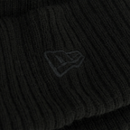 Gros plan sur un tissu noir orné d'un logo brodé, sur fond sombre