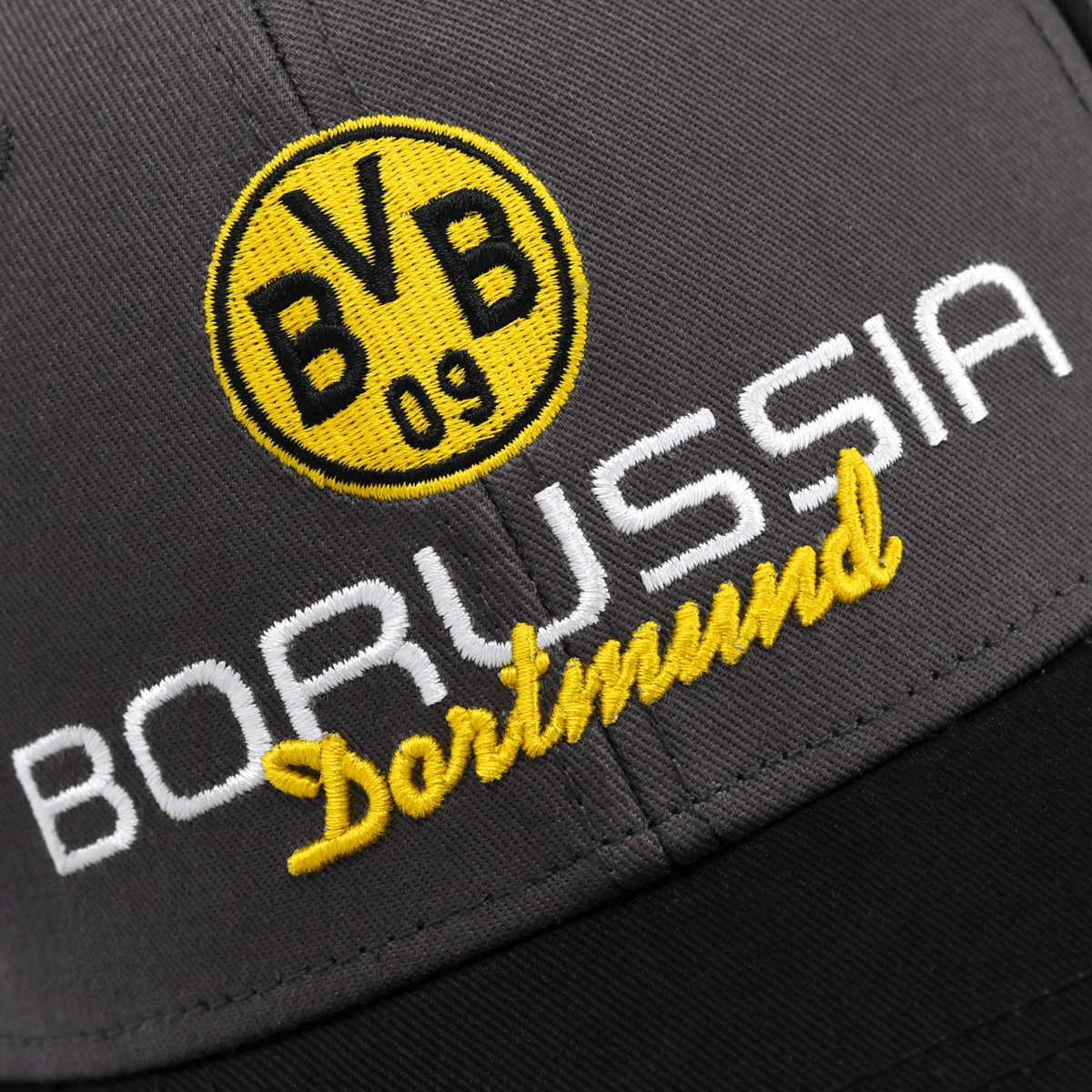 Gros plan sur la casquette du BVB, de couleur gris-noir, arborant le logo jaune du BVB et l'inscription « Borussia Dortmund » en blanc et jaune.