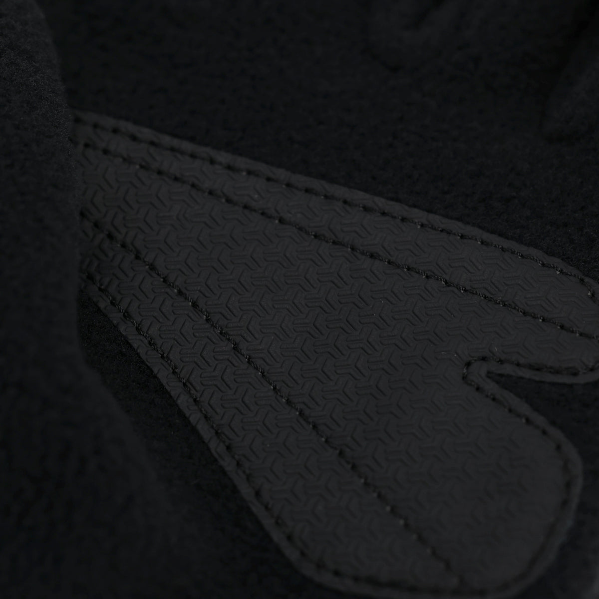 Schwarze BVB-Softshellhandschuhe in Detailaufnahme mit texturierter Oberfläche und Nahtverarbeitung. Borussia Dortmund Fanaccessoire.