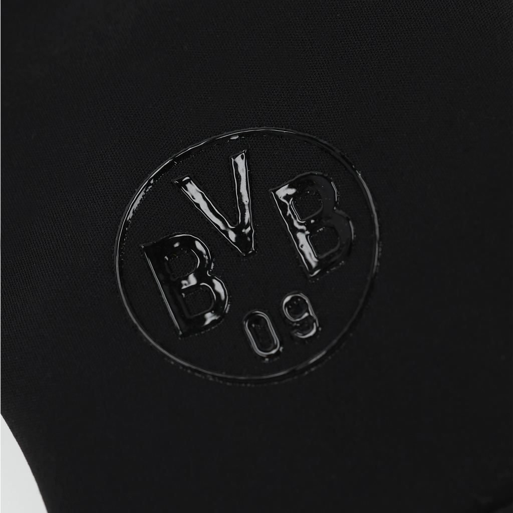 Schwarzes glänzendes BVB 09-Logo in Detailansicht auf dunklem Hintergrund.