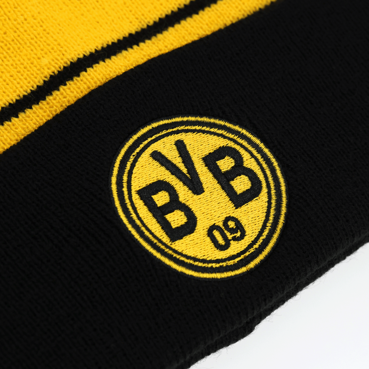 Primo piano di un berretto con pompon nero e giallo del BVB in stile retrò con il logo BVB-09 ben visibile, ideale per i tifosi del Borussia Dortmund.