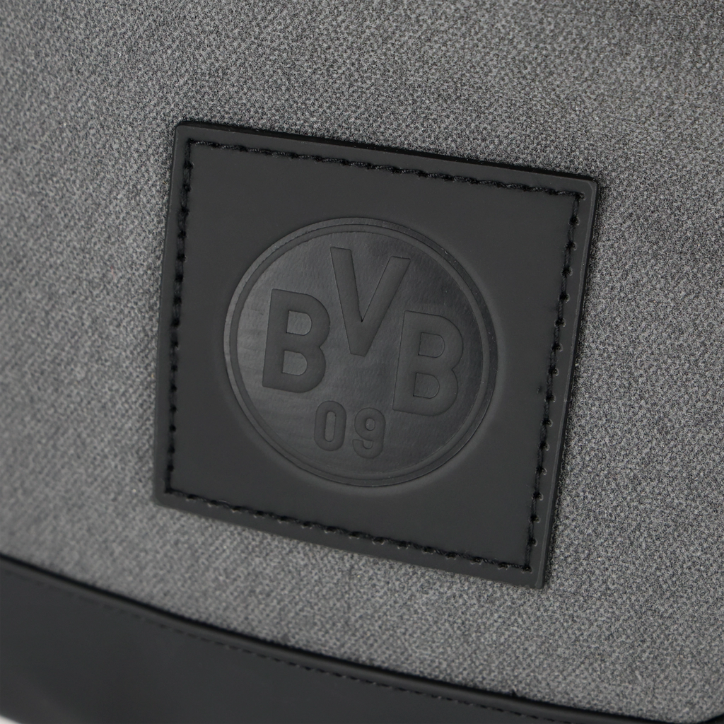 Zaino grigio del BVB con logo nero del Borussia Dortmund in forma circolare e dettagli in nero.