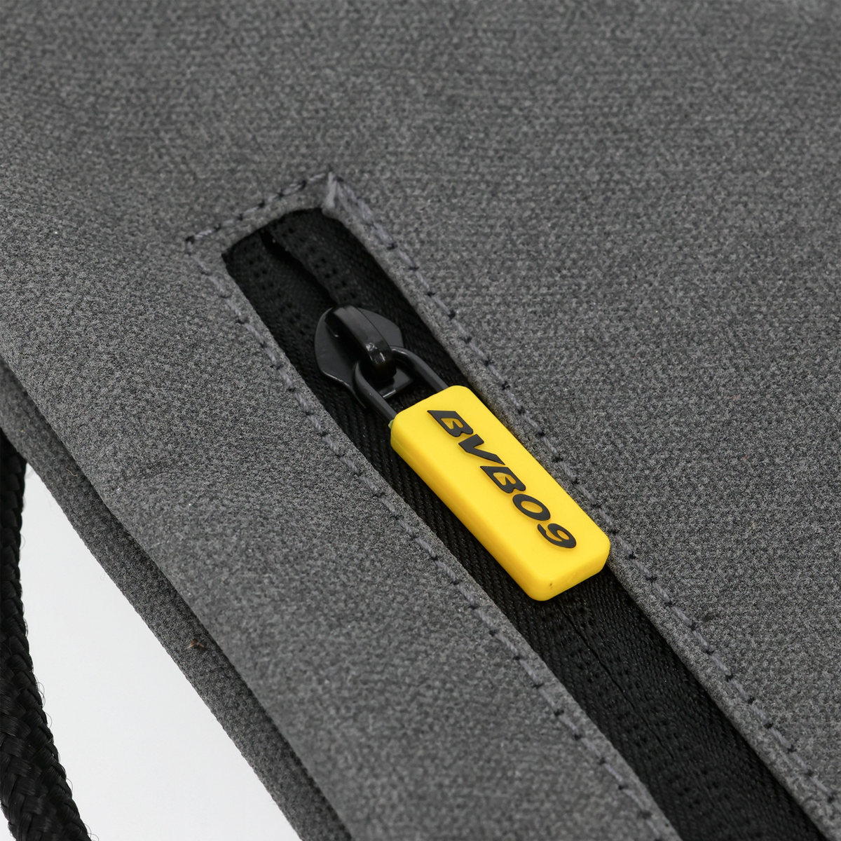 A gray Borussia Dortmund gym bag made of reflective material, featuring an eye-catching yellow zipper pull with the BVB 09 logo.