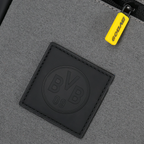 Detailansicht einer grauen BVB-Schultertasche mit schwarzem BVB-Logo und gelbem Reißverschlussanhänger.