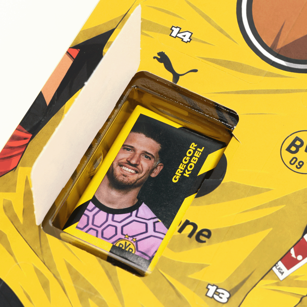 BVB Comic Advent Calendar 2026 in bright yellow with black-and-yellow details, the BVB emblem, and the PUMA logo, featuring 24 surprises; the door with the player's picture is open.