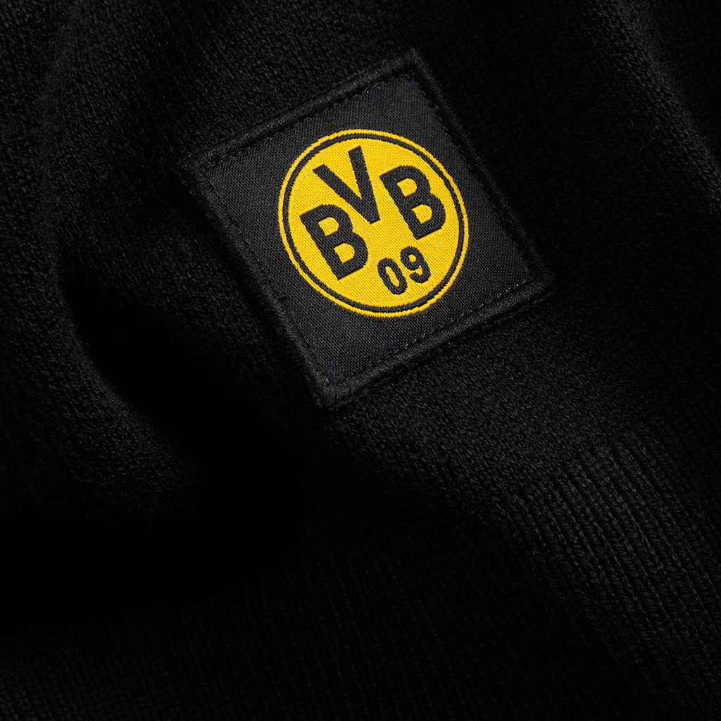 Nahaufnahme eines schwarzen Stoffes mit dem schwarzgelben BVB-Logo des Borussia Dortmund 09.