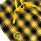 Schwarzgelb karierter BVB-Schlafanzug mit BVB-09-Logo und gelben Kordeln als Fanartikel.