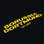 Detailaufnahme eines schwarzen BVB-Hoodies mit gelbem Borussia Dortmund Schriftzug und EST. 1909 Logo.