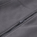 Die Detailansicht eines grauen BVB Zipjackets zeigt einen Reißverschluss. Der Stoff ist glatt und in einer einfarbigen grauen Ausführung gehalten.