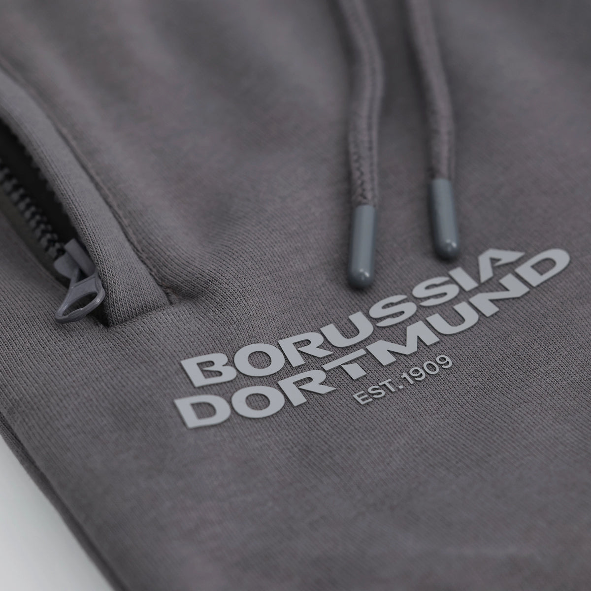 Graue BVB Urban Sweatpants mit Borussia Dortmund-Logo und Kordelzug, Detailaufnahme.