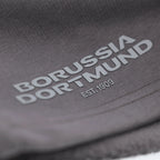 Graue BVB Urban Sweatshorts mit aufgedrucktem Borussia Dortmund Logo und EST. 1909 Schriftzug in Nahaufnahme.