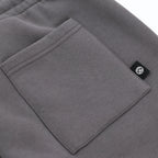 Graue BVB Urban Sweatshorts in der Detailansicht mit Tasche und schwarzweißem BVB-Logo, ideal als Fanartikel oder Streetwear geeignet.