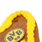 Corazón de pan de jengibre de 80 g con diseño en negro y amarillo, con el logotipo del BVB 09 y un ribete de glaseado amarillo.
