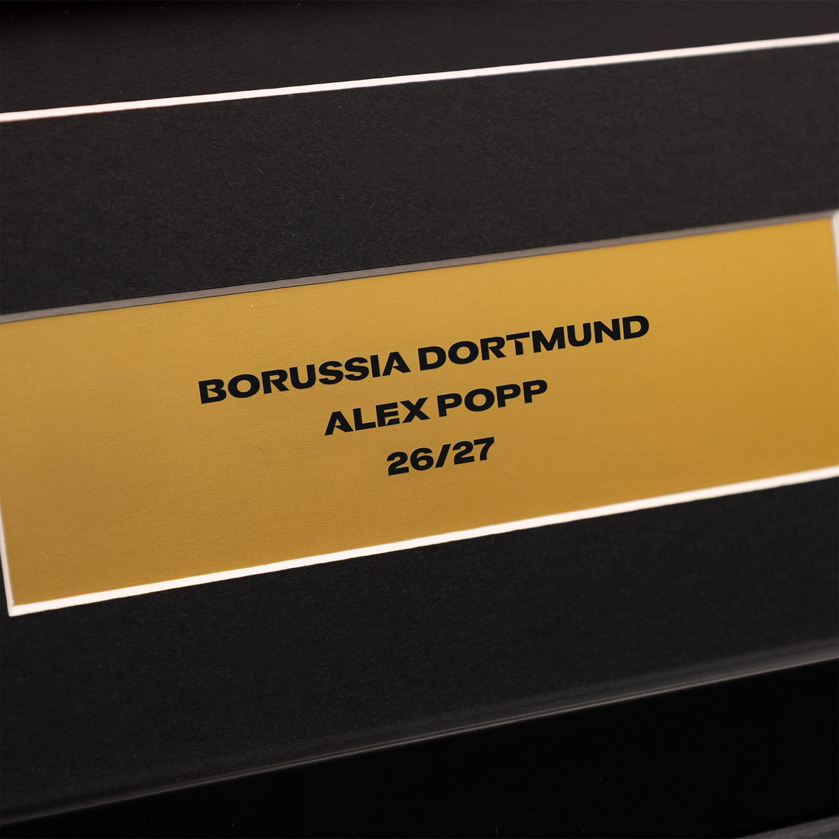 Schwarzer BVB-Trikotrahmen mit goldenem Schild, bedruckt mit Borussia Dortmund, Alex Popp und 26/27, ideal als Fan-Wanddekoration.