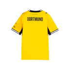 La camiseta de local del BVB de la temporada 26-27 para niños, en negro y amarillo; vista trasera con la inscripción «DORTMUND» en la espalda y el logotipo de PUMA en las mangas.