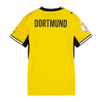 Vista trasera de la camiseta de local negra y amarilla del BVB para mujer, temporada 26-27, con la inscripción «DORTMUND» en la espalda.