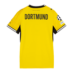 Vista trasera de la camiseta local del BVB para la temporada 2026/27 para mujer, en color amarillo con cuello negro, la inscripción «DORTMUND» y el escudo de la UEFA en la manga.