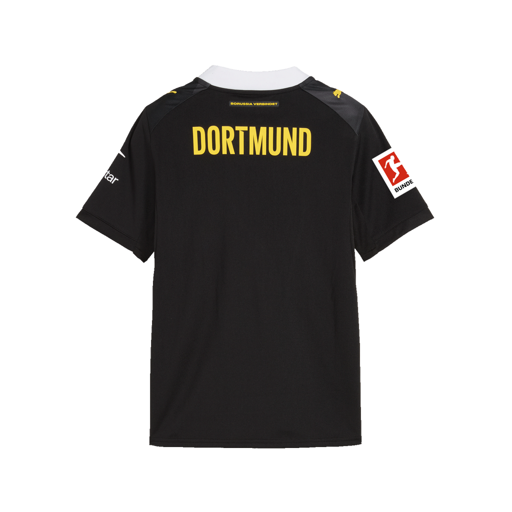La camiseta de visitante del BVB de la temporada 26/27, en negro y amarillo, para niños, vista desde atrás, con la inscripción «DORTMUND», el logotipo de la Bundesliga, cuello blanco y el logotipo de PUMA.
