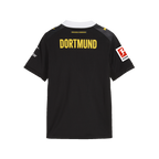 The black-and-yellow BVB 26/27 away jersey for kids, viewed from the back, featuring the "DORTMUND" inscription, the Bundesliga logo, a white collar, and the PUMA logo.