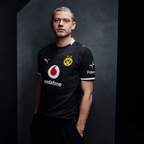 Schwarzes BVB-Trikot mit gelbem Vereinslogo, Vodafone-Logo, Polestar-Aufdruck und Puma-Logo in Frontansicht.