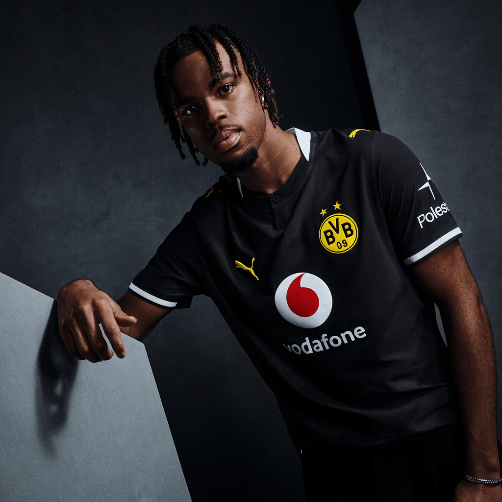 Schwarzgelbes BVB-Trikot mit Vodafone- und Polestar-Logos auf der Brust, Puma-Logo und BVB-Emblem, getragen von einem Modell in sportlicher Pose.