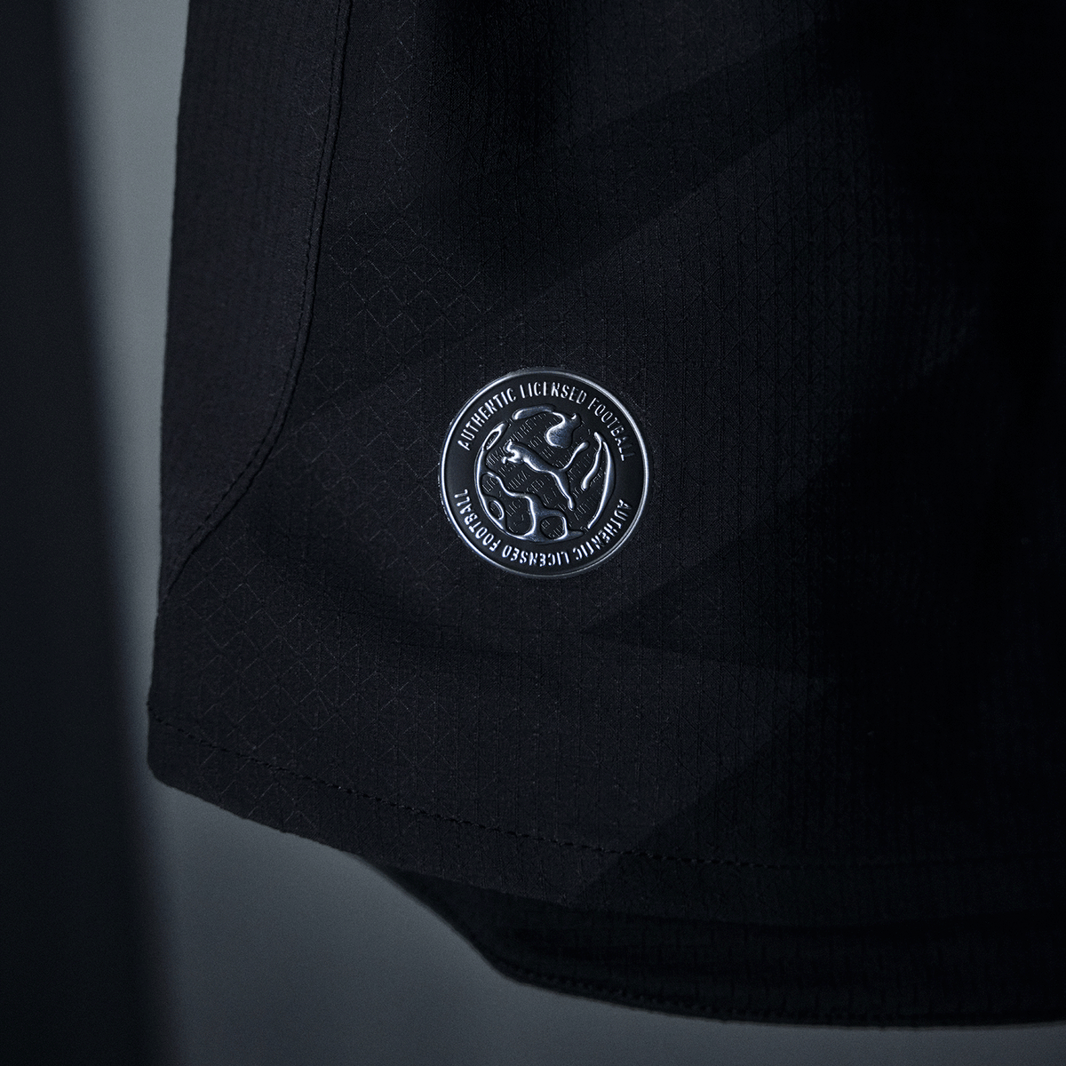 Detailansicht des BVB Auswärtstrikots Authentic für die Saison 2026/27 in schwarzem Design mit dezentem Muster und Lizenzanhänger.