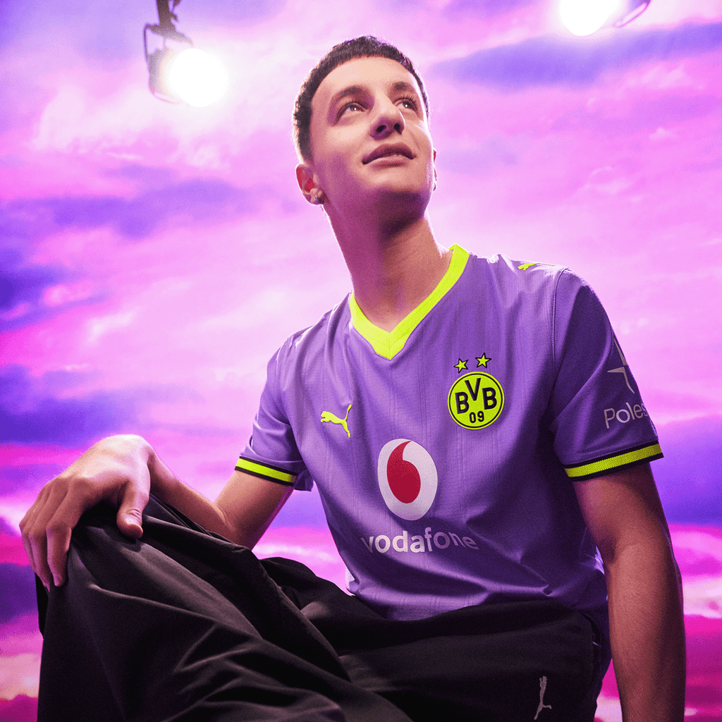 The purple BVB 26/27 away jersey with neon yellow accents, featuring the Vodafone and Polestar logos, is presented in a modern design and shown against a purple background.