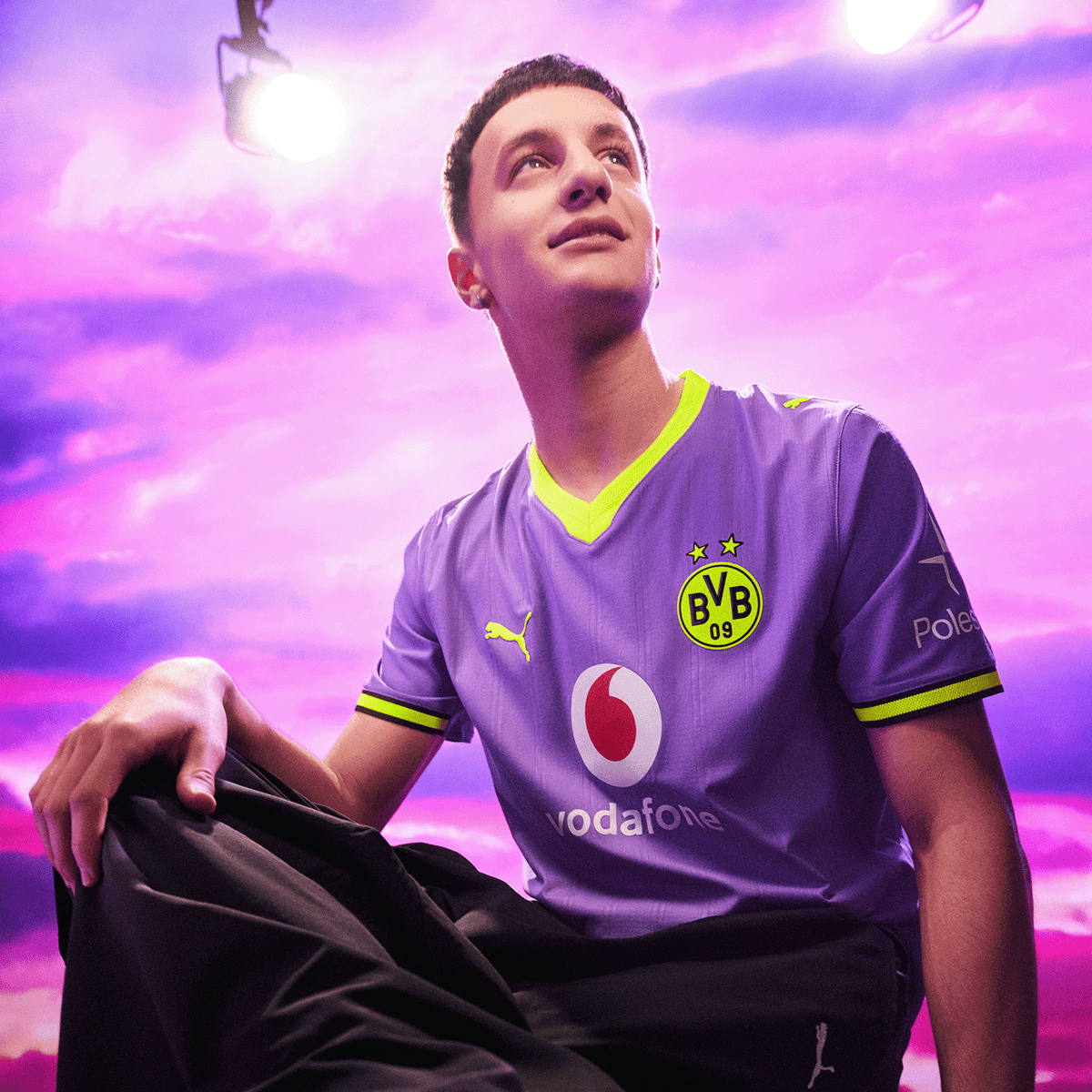 The purple BVB 26/27 away jersey with neon yellow accents, featuring the Vodafone and Polestar logos, is presented in a modern design and shown against a purple background.