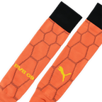 Orangefarbene BVB 09 Torwart-Stutzen mit schwarzem Abschluss, gelbem Puma-Logo und BVB 09-Schriftzug. Detailaufnahme des Designs.