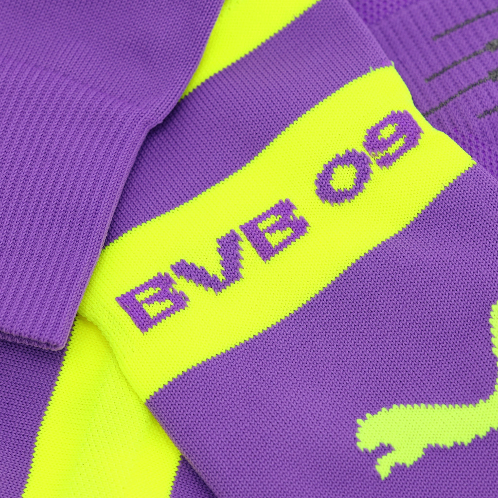 Nahaufnahme von lila BVB-Stutzen mit gelbem Mittelstreifen, BVB 09 Schriftzug und Puma-Logo, offizieller Fanartikel von Borussia Dortmund.