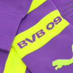 Nahaufnahme von lila BVB-Stutzen mit gelbem Mittelstreifen, BVB 09 Schriftzug und Puma-Logo, offizieller Fanartikel von Borussia Dortmund.