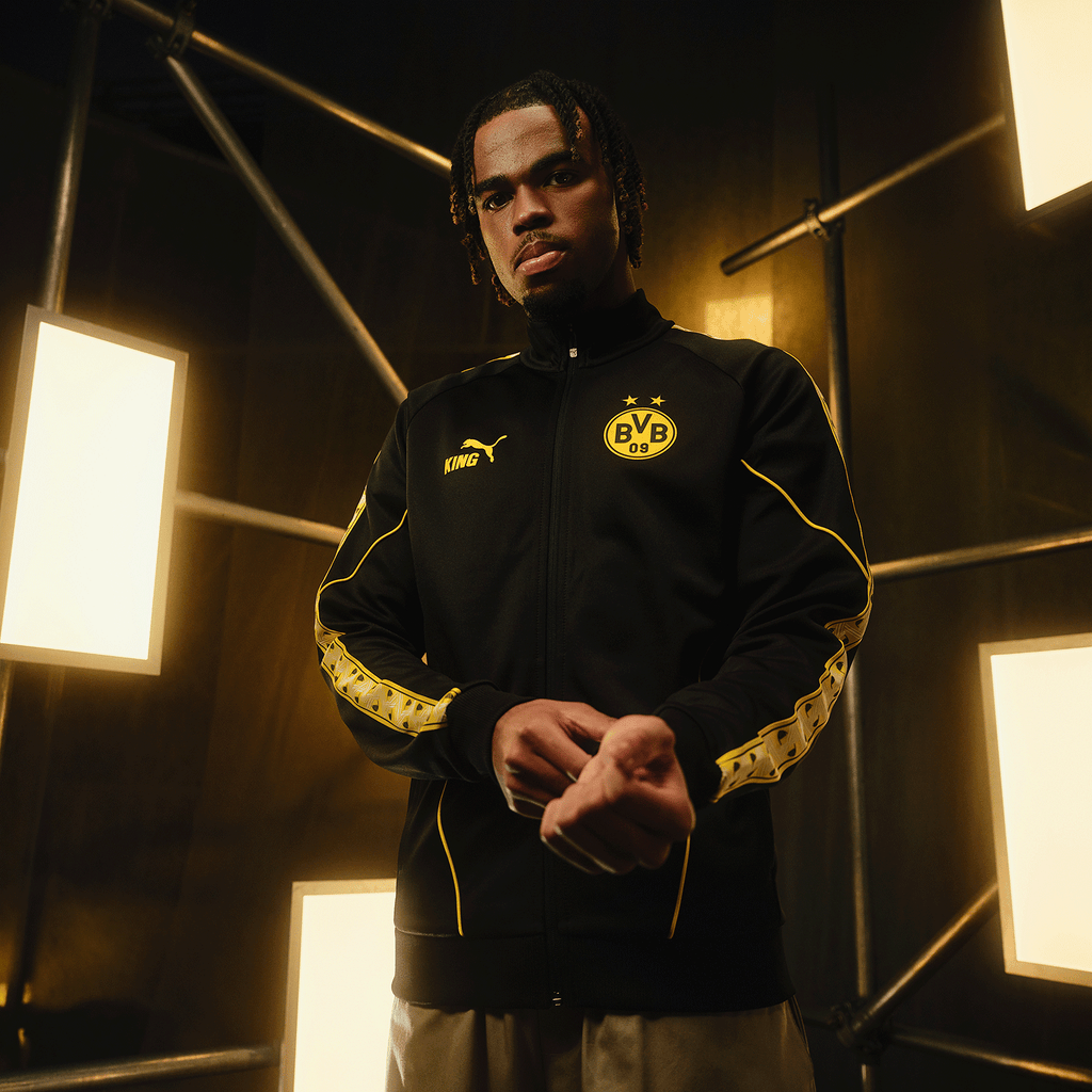 Black-and-yellow BVB King Anthem jacket from the 2026/27 season featuring the BVB 09 emblem and the PUMA logo, shown from the front on a model.
