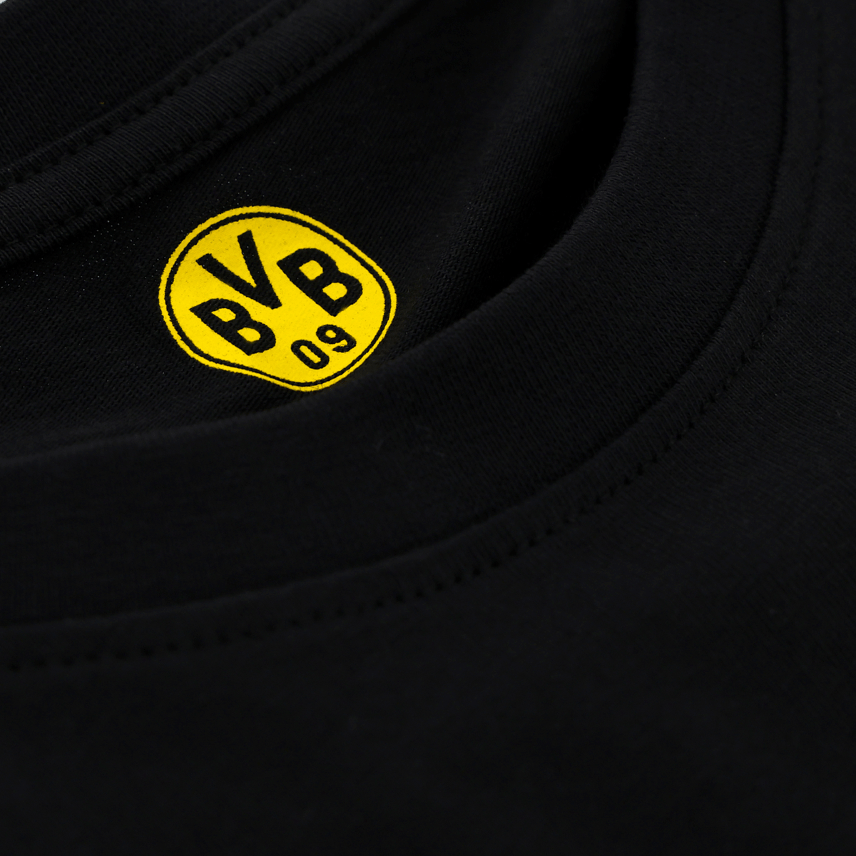 一件黑色与黄色相间的多特蒙德（BVB）儿童T恤的特写镜头，领口处印有标志性的BVB 09徽标。