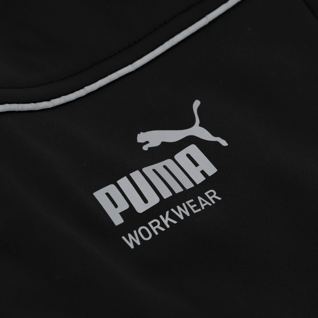 PUMA黑色软壳工装夹克，正面印有醒目的白色PUMA Workwear标志，既适合作为工作服，也适合休闲穿着。