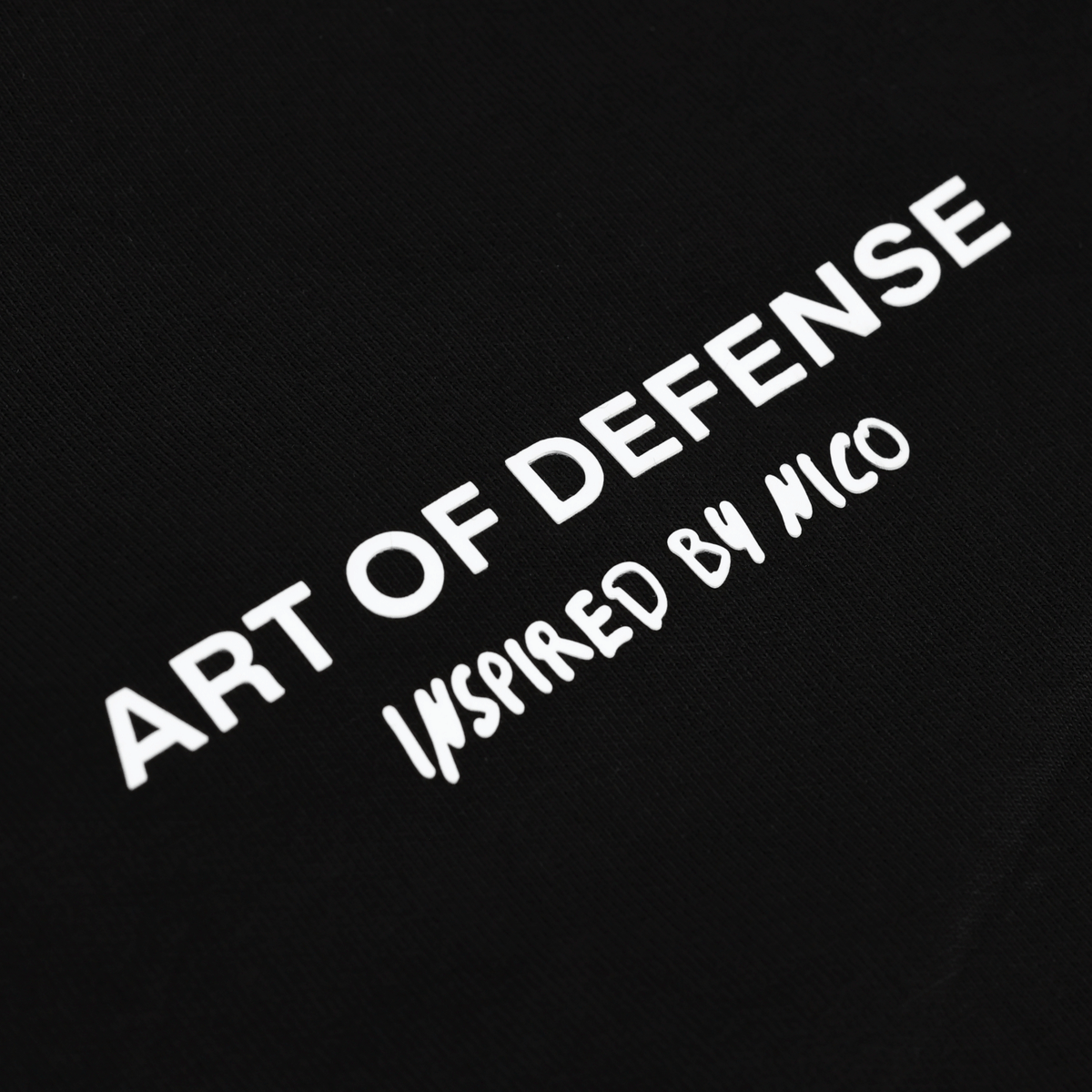 Photo détaillée du pantalon de survêtement noir du BVB orné de l'inscription blanche « Art of Defense - Inspired by Nico », idéal pour les supporters du Borussia Dortmund.