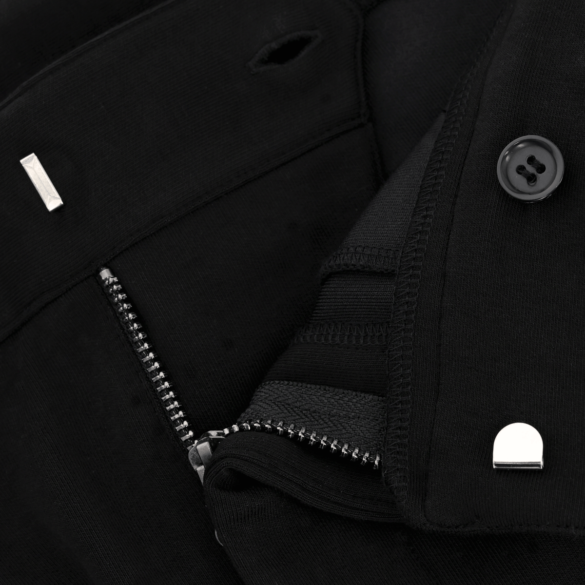 Gros plan sur le pantalon de sport BVB INBY III noir, doté d'une fermeture à glissière et d'un bouton aux détails soignés.