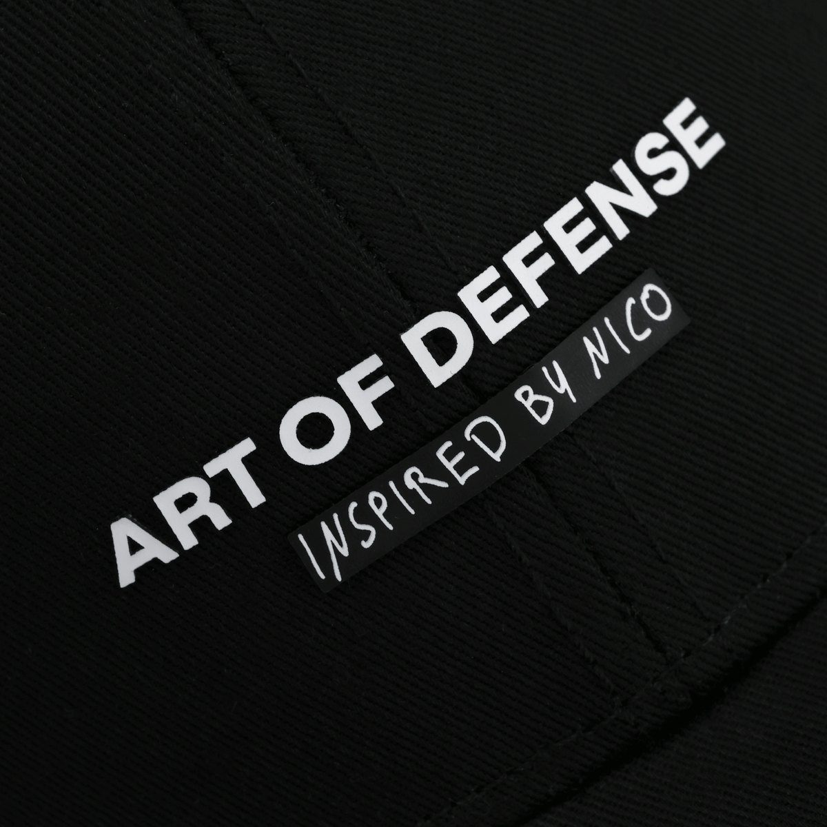 Schwarze BVB-Cap mit auffälligem weißem Schriftzug 'Art of Defense' und darauf bezogenem Zusatz 'Inspired by Nico'.