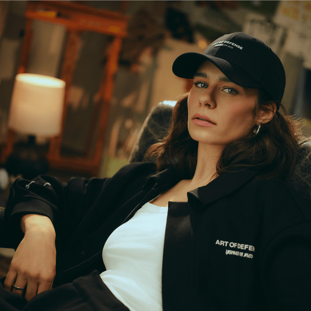 Cappellino nero del BVB dal design elegante con logo ricamato, indossato da un giovane in un ambiente informale.