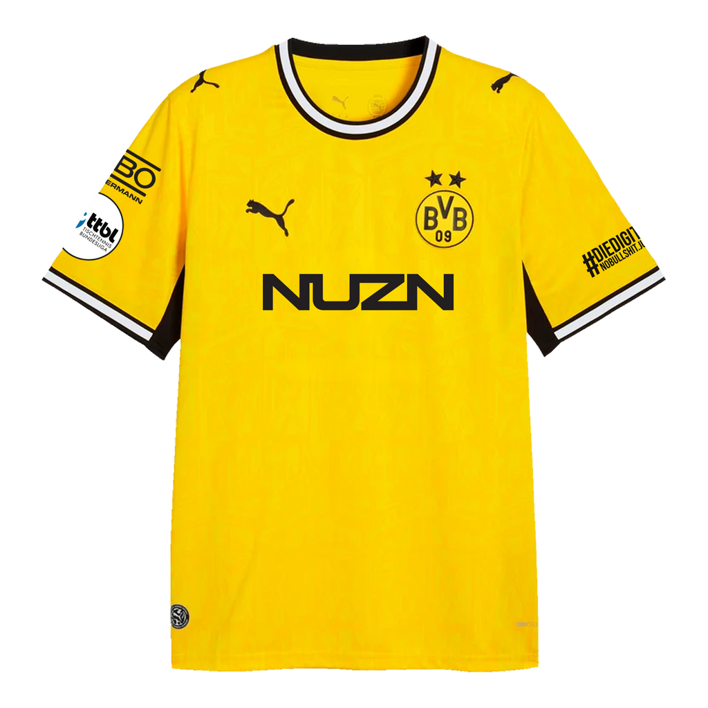 La camiseta de local del BVB para la temporada 26-27, de color negro y amarillo, de PUMA, muestra el escudo del BVB, el logotipo de PUMA, la inscripción «NUZN» y los logotipos de los patrocinadores en ambas mangas, vista de frente.