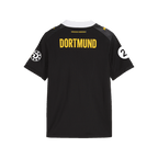 The photo shows the back of the black-and-yellow BVB 26-27 away jersey for girls' soccer, featuring the "DORTMUND" lettering and the Puma logo.