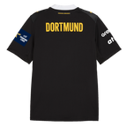 Vista posteriore della maglia da trasferta del BVB per la stagione 26-27, di colore nero con la scritta “DORTMUND” in giallo, il logo della EHF Champions League e i loghi degli sponsor sulle maniche.