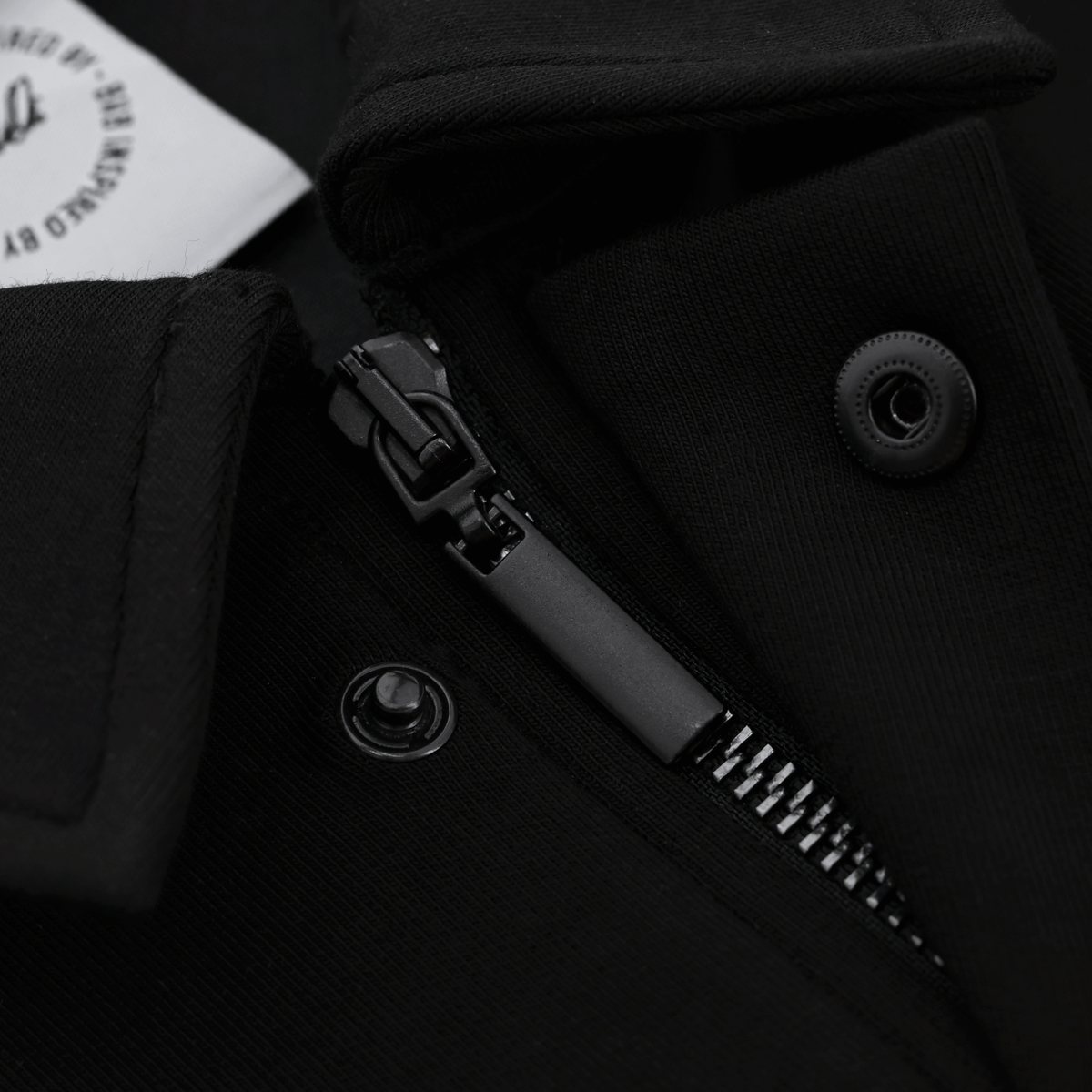 Detailansicht eines schwarzen BVB-Inby III Tracksuits mit Reißverschluss und Knopfverschluss.
