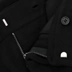 Detailansicht eines schwarzen BVB-Tracksuits mit Reißverschluss, Knopf und feinen Stoffnähten.