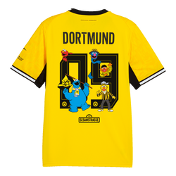 Camiseta amarilla de local del BVB para mujer de la temporada 26/27 con diseño de Barrio Sésamo, detalles en negro y amarillo, el escudo del BVB y personajes como el monstruo de las galletas y Ernie.